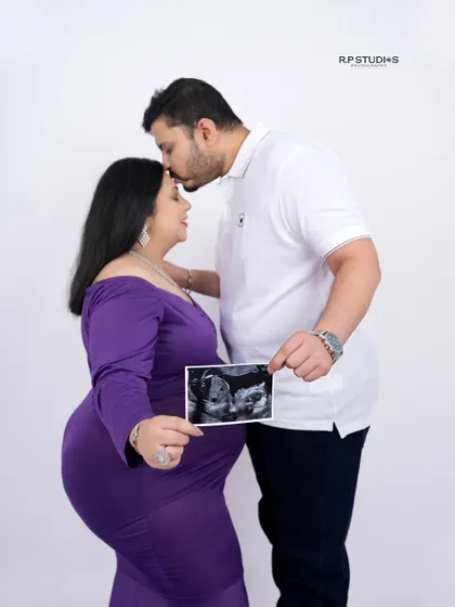 A tender moment between partners, holding the ultrasound picture that shows the first glimpse of their baby. A memory to cherish forever.