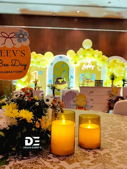 A view of the dining area at Keev's 'Bee Day' party, with themed centerpieces and candles creating a warm ambiance.