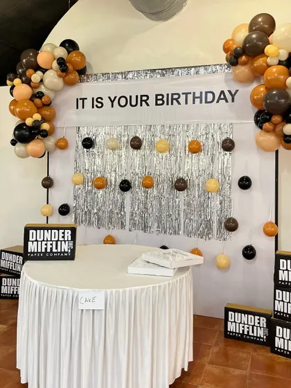 The 'Dunder Mifflin' party entrance featured a welcome sign from the "party planning committee" and stacks of branded paper boxes, setting the tone for 'The Office' theme.
