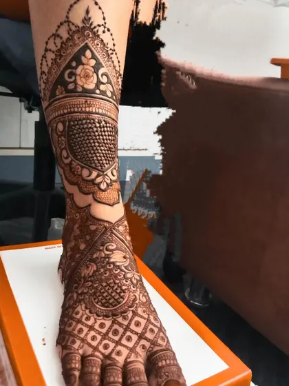 A close up of a bridal leg design, showing the intricate details and fine lines. The pattern is a beautiful mix of traditional and floral motifs.