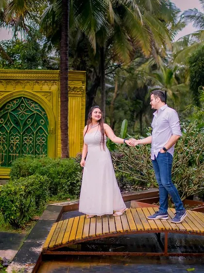 A romantic walk across the bridge. This candid shot in simple, light-colored casual wear feels authentic and full of sweet anticipation.