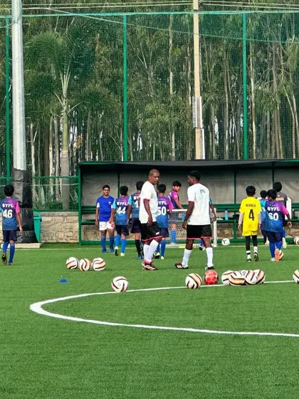 Coaches setting up drills with multiple balls, preparing for an intense technical session.