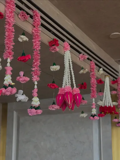 We created a breathtaking ceiling with hundreds of hanging floral strings (latkans) in shades of pink and white, transforming the room into a fragrant, festive canopy for a wedding celebration at home.