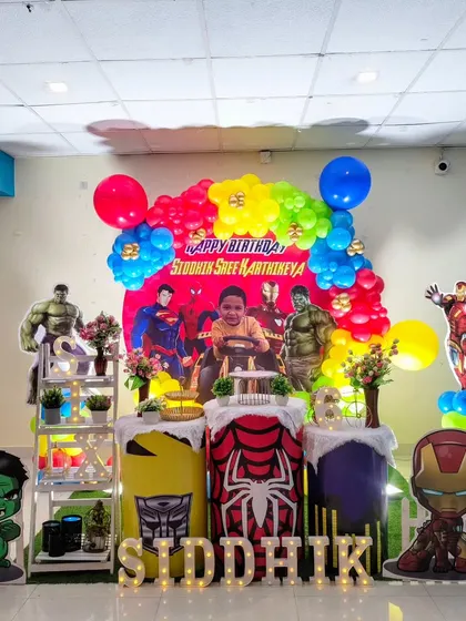 An action-packed Avengers superhero theme for a young fan. The decoration includes a colorful balloon garland and cutout's of favorite hero's like the Hulk, Iron Man, and Superman.