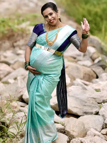 Waving with joy. This full-length shot shows the complete look, from the elegant saree draping to the radiant makeup.