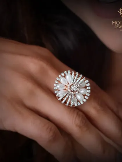 A floral-inspired ring where lustrous pearls form the petals. This piece combines the classic elegance of pearls with the sparkle of a central diamond cluster in a unique and feminine design.