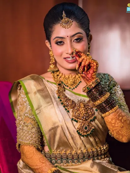 A playful and charming shot of the bride. Her custom gold blouse and traditional jewelry are a perfect match.