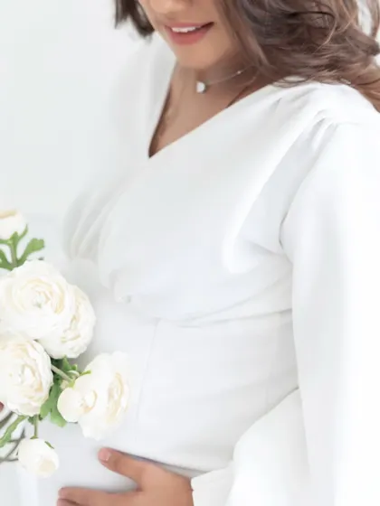 It's all in the details. This close-up shot focuses on the mother's hands and the beautiful flowers, adding an artistic and delicate touch to the maternity gallery.