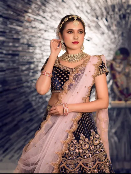 This Kundan jewelry set is perfect for a royal-themed event. The set includes a statement choker, long earrings, and a delicate matha patti, paired here with a navy blue velvet lehenga for a rich, elegant look.