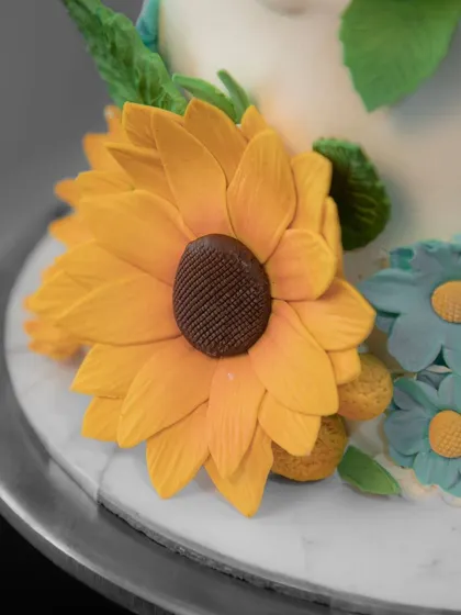 A close-up of a single, perfect sugar sunflower, showcasing the detailed craftsmanship of each petal.