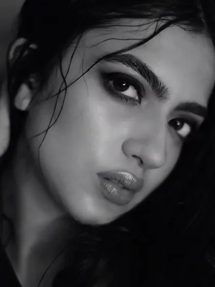 This shot captures the full effect of the wet hair look, with strands artfully placed across the face. The glossy lips and luminous skin complete this edgy, high-fashion aesthetic.