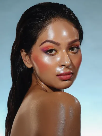 A warm, sunset-inspired glass skin look with a blend of orange and pink. The wet-look hair completes this stunning, high-fashion concept.