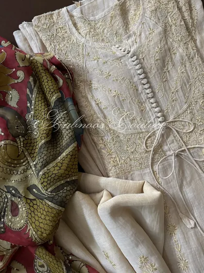 A composition showing the Anarkali bodice alongside the rich, artistic detail of the maroon Kalamkari dupatta, highlighting the peacock and vine motifs.