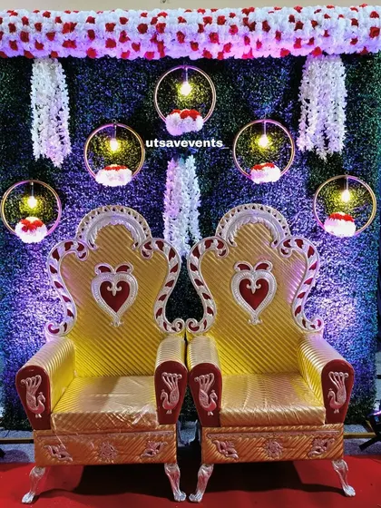 A wider view of the engagement decor with the grass wall and ornate chairs, showing the uplighting that adds a dramatic effect to the setup.