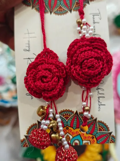 For a bold and beautiful statement, these crochet rose lumba rakhis are perfect. They come with delicate pearl strings and tiny bells.