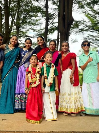 All people smile in the same language. The whole group, dressed in traditional clothes, comes together for a happy photo.