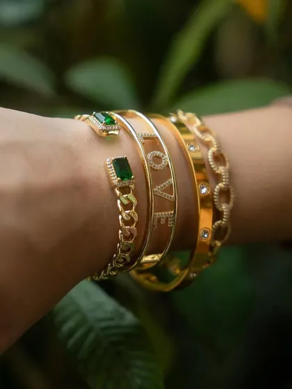 A sophisticated stack featuring my gold and emerald collection. The 'LOVE' cuff bangle pairs beautifully with the emerald loop and oval link chain bangles.