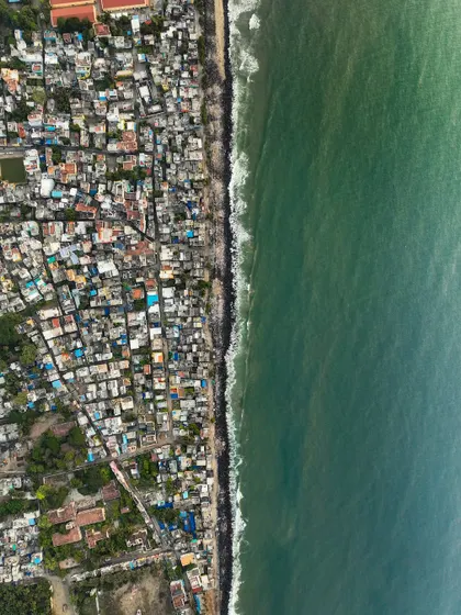 A top-down view of a city slum right next to the sea. This shot offers a powerful commentary on the contrasts of urban life and our relationship with the environment.