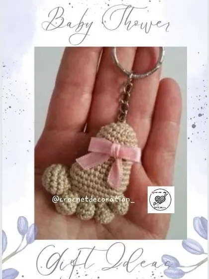 A beautiful baby feet keychain in a neutral color with a pink bow. These are thoughtful and customizable gifts for baby showers, gender reveals, or to welcome a new baby.