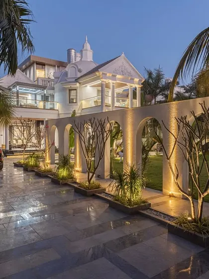 The entrance to the Tropical Manor is defined by this dramatic arched wall, which I designed to create a sense of arrival and discovery. At night, landscape lighting highlights the architectural rhythm, framing views of the garden and guiding the way with a soft glow.