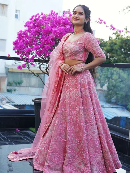 This fully embroidered pink lehenga is perfect for a bride or bridesmaid. The tone-on-tone embroidery creates a rich texture, while the net dupatta adds a layer of softness to the overall look.