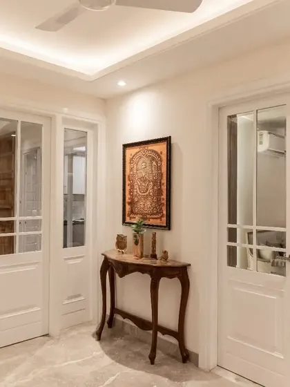 The entrance of this apartment fuses timeless elegance with modern sophistication. The classic white French doors, console table, and traditional artwork create a welcoming and stylish first impression.