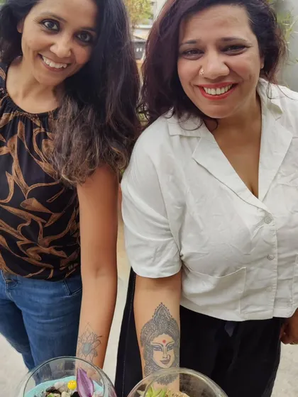 Two friends smiling with their newly created terrariums. These workshops are a great opportunity to foster inner joy and social connections.