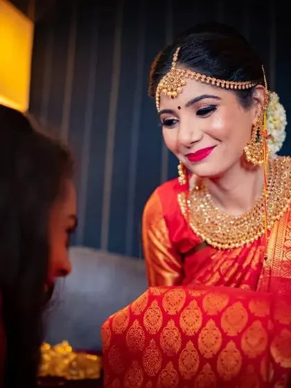 A heartwarming moment between the bride and another family member, sharing a beautiful red saree.