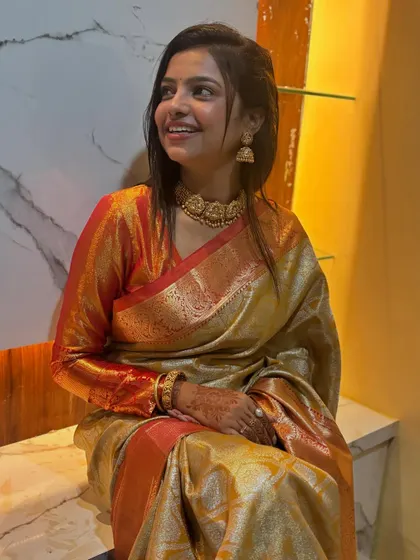 A happy, smiling Sonu seated in her new home, looking radiant in our traditional Kanjeevaram saree.
