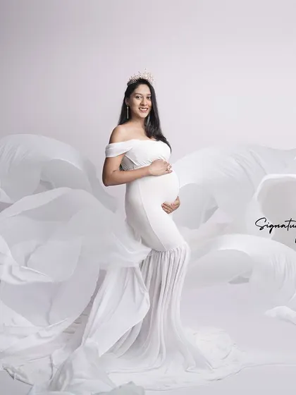 The flowing white fabric creates a sense of movement and grace in this dynamic studio shot.