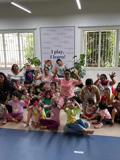 The whole school community shows off their colorful hands, celebrating Holi together.