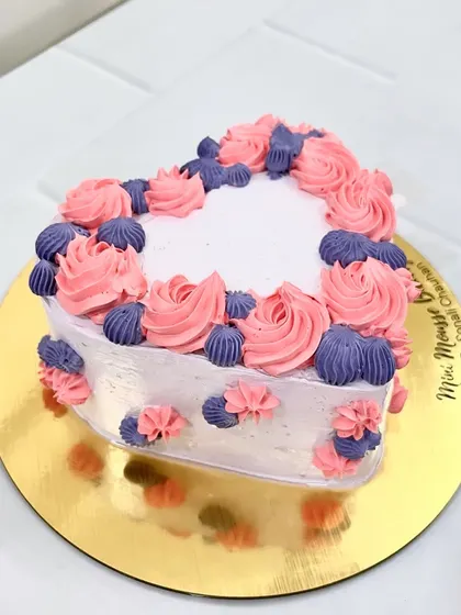 A heart-shaped bento cake with pretty pink and purple piping. It's a lovely little cake for any romantic occasion.