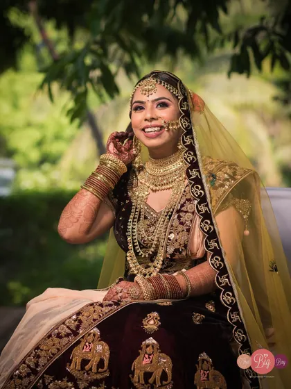 The bride, Rashi, shares a joyful, candid laugh, her heavy traditional jewelry and bright smile shining.
