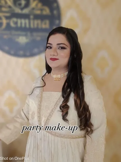 A sophisticated party makeup look for a client in a beautiful white and gold outfit. The makeup is kept elegant with defined eyes and a classic red lip.