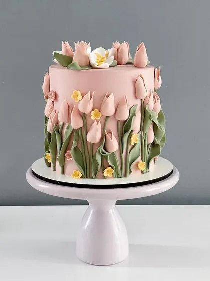 A beautiful pink cake decorated with a field of handcrafted sugar tulips. This design is perfect for celebrating spring, Mother's Day, or any joyful occasion.