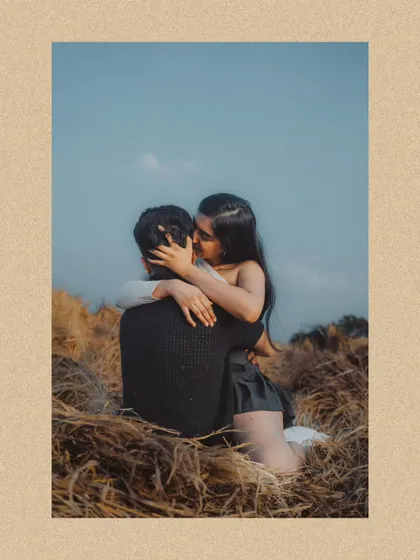 An intimate embrace in a field of gold. This beautifully framed shot from a pre-wedding session uses natural elements to create a sense of privacy and romance.