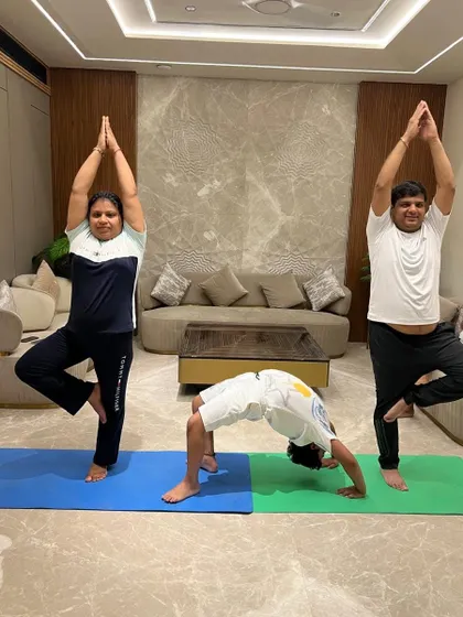 A fun and challenging moment from a corporate session, with participants trying Vrikshasana and Chakrasana. Yoga at work can boost team morale and physical health.