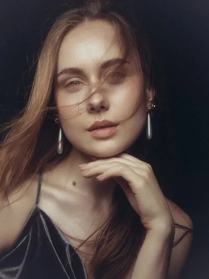 The wind-blown hair adds a touch of softness to this natural beauty shot, with the focus remaining on the luminous skin.