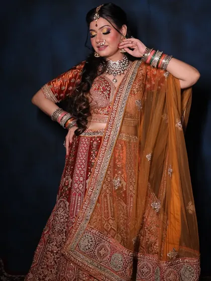 This rust-orange bridal lehenga is perfect for a day wedding. I paired it with a silver-toned choker and matching bangles to create a balanced and elegant look, all available for rent.