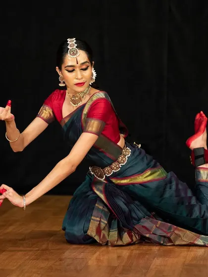 A complex floor posture that requires flexibility and strength, demonstrating the physical discipline of Bharatanatyam. This was part of a longer narrative piece.