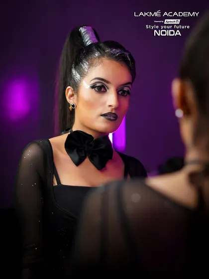 A mirror portrait of a gothic-inspired glam look. The black bow tie and sharp makeup lines create a powerful and confident image.
