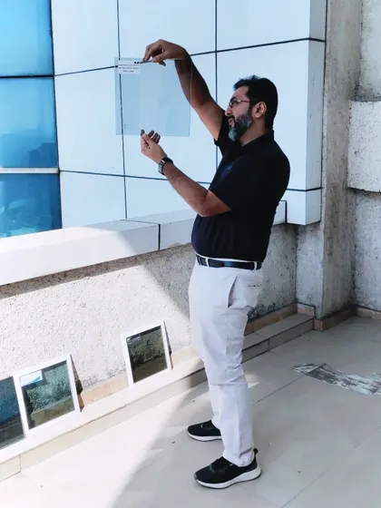 A photo of our principal architect inspecting glass samples against a building facade to check for color and transparency.