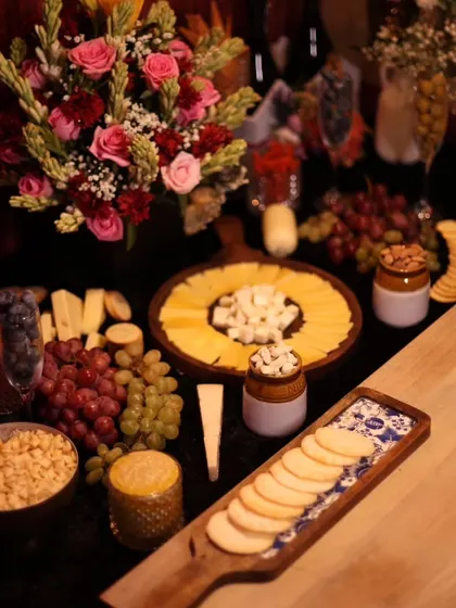 A beautiful grazing table we created for an influencer event. The spread includes a variety of cheeses, crackers, fruits, and nuts, all artfully arranged with floral bouquets.