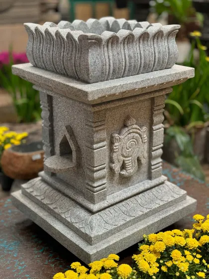 A Tulasi Brindavan made of grey granite, featuring the sacred Shanku and Chakra symbols. This piece represents divine harmony and serves as a beautiful focal point for daily prayers and offerings in a garden.