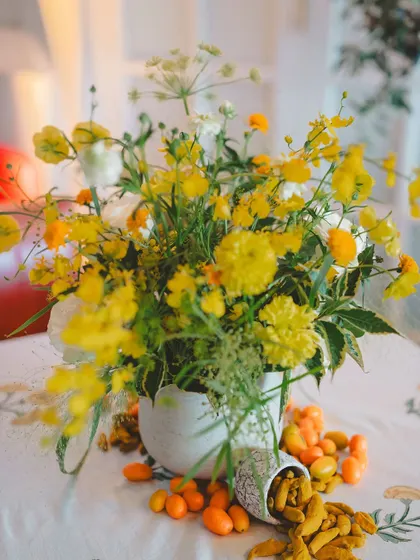 A sunny Haldi ceremony in the British countryside, with details like "Love is all we need" henna, fresh yellow flowers, and bowls of rose petals.