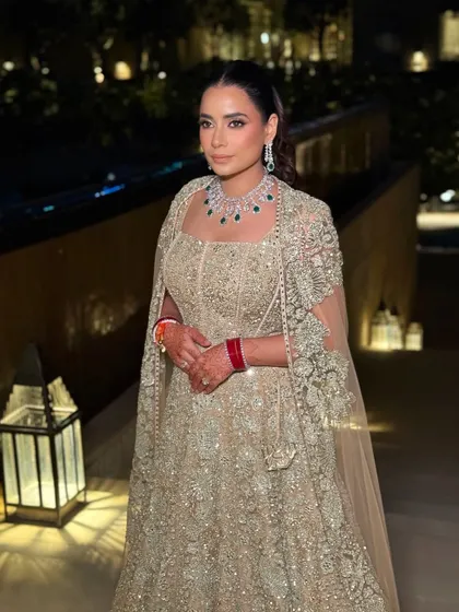 The bride's reception look captured in the warm evening light. Her makeup is radiant and polished, with a soft smoky eye that enhances her features beautifully.