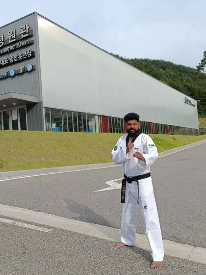 Posing in front of the Pyeongwon-gwan building at Taekwondowon.