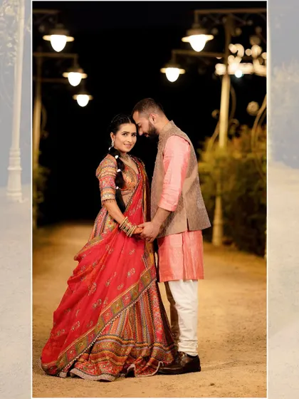 A romantic nighttime portrait, with the couple standing close on a path lit by streetlights, creating a warm and intimate ambiance.