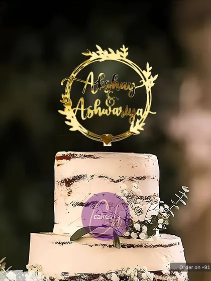 I love the simplicity of a rustic, semi-naked cake. This two-tiered design for Akshay and Aishwarya is complemented by a golden wreath topper, perfect for weddings, engagements, or anniversaries.