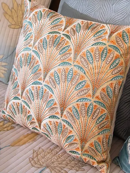 Browse through my extensive collection to find the design that speaks to your heart. This cushion, with its art-deco-inspired fan pattern in orange and teal, offers a bold and artistic statement.